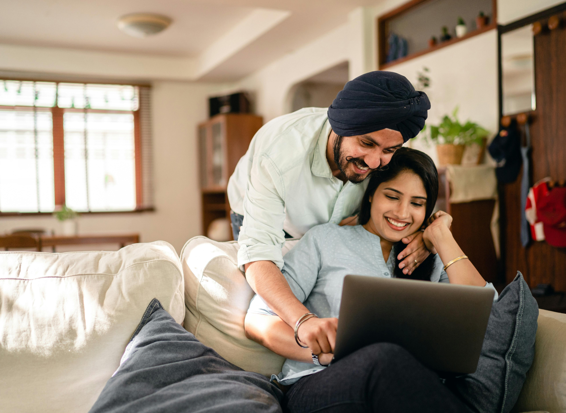 a man and women look at a laptop while planning their wedding